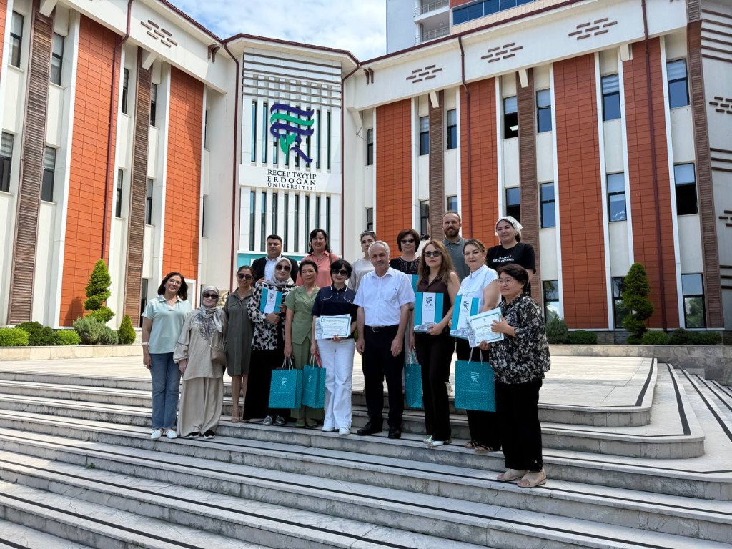 Universitet zinapoyasida sertifikatlar bilan guruh surati